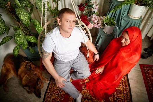 Couple dressed in oriental attire engage in playful role-playing at home, creating a joyful atmosphere with their pets.