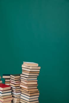 Stacks of old educational books for study in the library on a green background