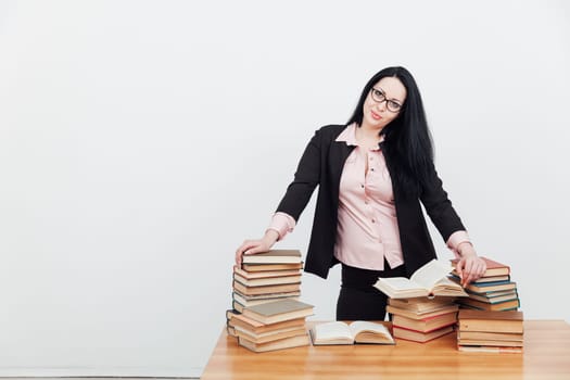 businesswoman teacher and stacks of educational books on table