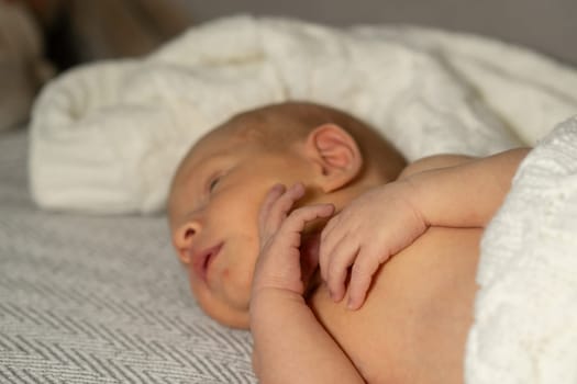 A small baby peacefully rests on a soft blanket, cherishing a moment of tranquility while wrapped in warmth and comfort in a serene environment.