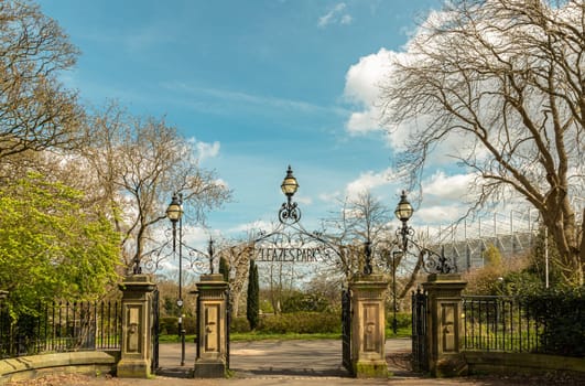 Newcastle, UK - Apr 13, 2025 - View of Cast iron lamp over the Wrought iron gate is open to the entrance of Leazes park with beautiful sky background. use it as your Wallpaper, Poster and Space for text, Selective focus.