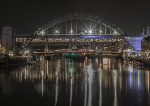 Newcastle, UK - Apr 13, 2025 - Stunning night view of the Newcastle upon tyne with Tyne bridge, Swing bridge and The High level bridge spanning the River Tyne connecting Newcastle upon tyne and Gateshead in North East England. use it as your Wallpaper, Poster and Space for text, Selective focus.