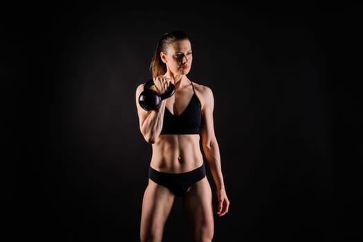 Fitness woman doing crossfit exercising with a kettle bell with muscular fit and slim body.