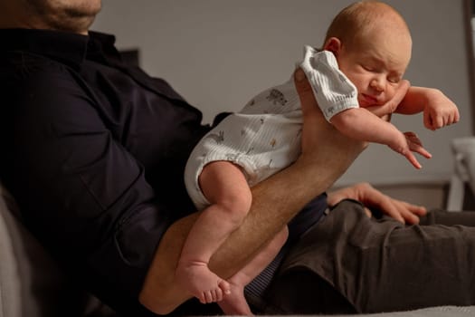 A parent gently holds a newborn baby in a cozy living room, showcasing a tender moment in the warm glow of evening light.