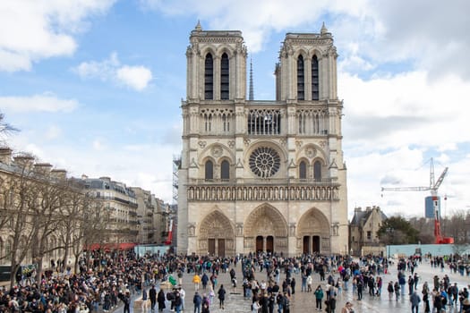 Paris, France - February 22nd 2025 : visitors in The Notre-Dame de Paris, newly re-opened cathedral restored after reconstruction, details of exterior