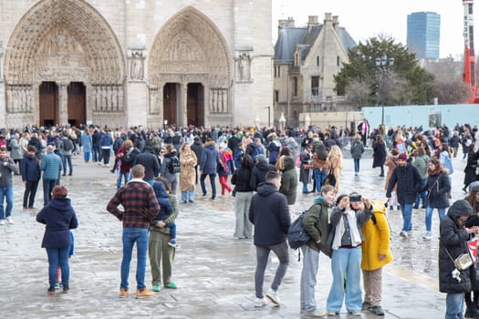 Paris, France - February 22nd 2025 : Notre-Dame de Paris and tourists in front of a newly re-opened cathedral after reconstruction
