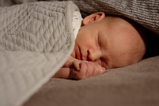 A mother lovingly holds her sleeping baby wrapped in a soft blanket, creating a serene atmosphere in their warm and inviting bedroom space.