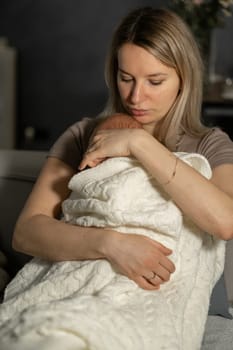 A mother tenderly holds her newborn in a cozy living room, radiating love and warmth in a peaceful moment.