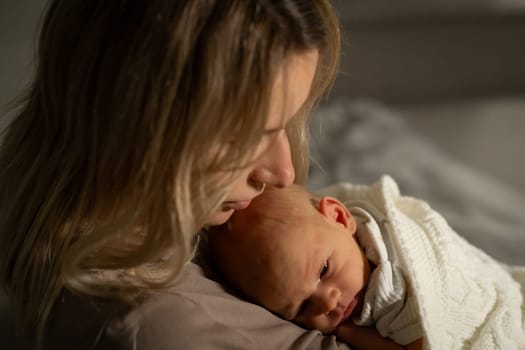 Mother lovingly cradles her newborn in a softly lit room, showcasing a tender connection and calm atmosphere during the quiet evening hours