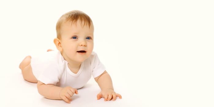 Portrait of happy cute baby crawling on the floor on white studio background