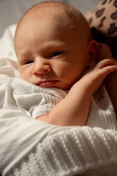 A mother lovingly holds her newborn baby close in a serene setting, creating a nurturing bond in a cozy atmosphere during the day.