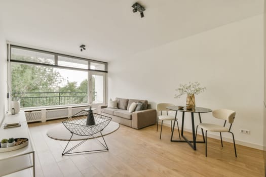 A stylish minimalist living room featuring a neutral color palette, modern furniture, and ample natural light from large windows enhancing the inviting atmosphere.