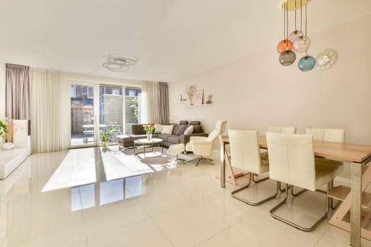 A spacious and bright modern living room featuring elegant furniture, large windows, and stylish decor elements that enhance the atmosphere of comfort and tranquility.