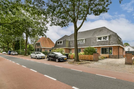 A picturesque residential street featuring charming houses surrounded by lush trees and parked cars, creating a tranquil neighborhood atmosphere.