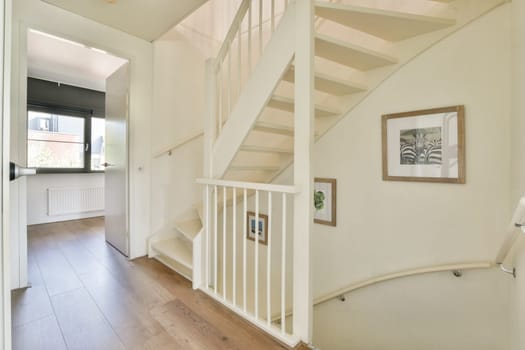 A stylish and modern interior showcasing a staircase illuminated by natural light, featuring minimalist decor and elegant design elements.