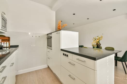 A sleek modern kitchen featuring minimalistic cabinetry, a stylish countertop, and subtle decorative elements, creating a spacious feel.