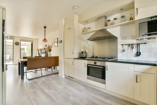 A modern kitchen featuring sleek cabinetry, stainless steel appliances, and a well-organized layout, illuminated by natural light from nearby windows.