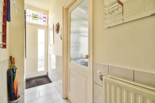 A well-lit entrance hall featuring sleek doors, tiled flooring, and colorful stained glass accents, creating an inviting atmosphere.