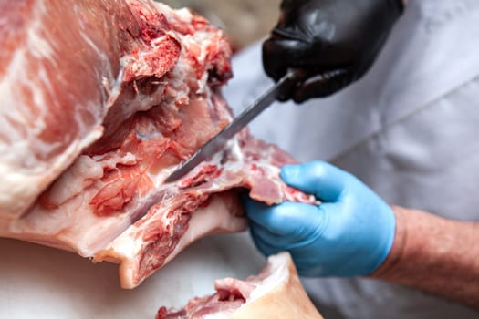 Butcher cutting a pork on a stall