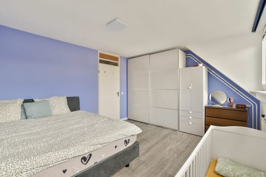 A well-designed modern bedroom featuring a stylish bed, ample storage, and a minimalist aesthetic. The soft color palette creates a serene atmosphere.