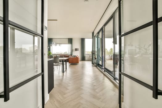 A stylish modern interior showcasing an open layout with large windows, vibrant furniture, and elegant decor elements that create a welcoming atmosphere.