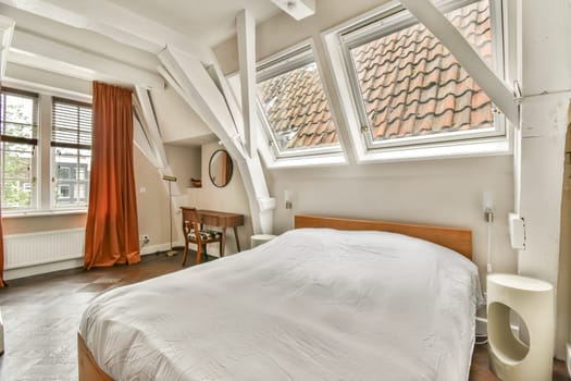 A beautifully designed modern bedroom featuring large windows that allow plenty of natural light, creating a warm and inviting atmosphere.