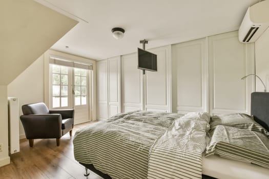 An inviting modern bedroom featuring a cozy bed, a stylish chair, and large windows that allow natural light to fill the space.