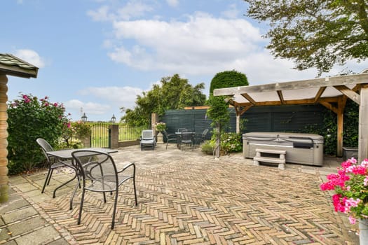 A serene outdoor patio area adorned with vibrant flowers and a cozy seating arrangement, ideal for relaxation and gatherings amidst nature.