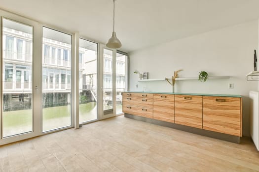 Bright and airy room featuring large windows, wooden cabinets, and a serene view of the water, promoting a calm and inviting atmosphere.