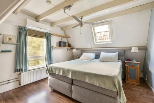 This inviting modern bedroom features a comfortable bed, soft linens, and abundant natural light from large windows, creating a serene atmosphere.