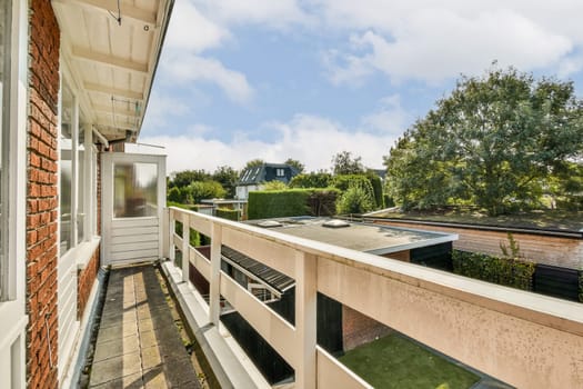 A scenic balcony overlooking vibrant greenery, offering a peaceful escape with a glimpse of modern architecture in the distance.