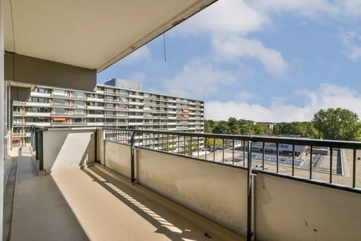A spacious balcony offering a view of contemporary architecture and greenery, showcasing a perfect blend of urban living with nature.