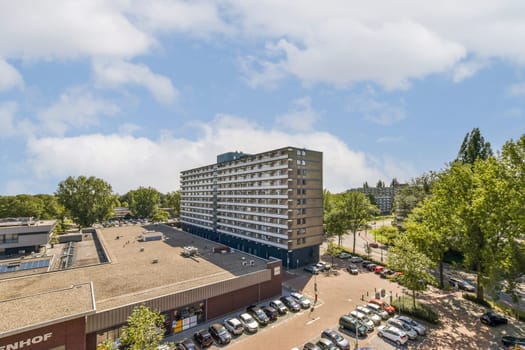 A contemporary urban scene featuring modern buildings amidst greenery and blue skies, showcasing a blend of architecture and nature.