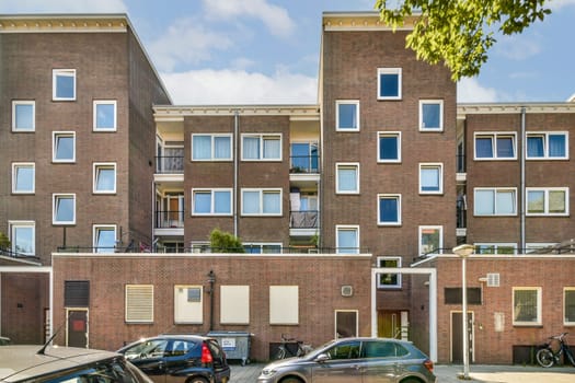 A contemporary multi-story apartment building featuring distinct structures, balconies, and a blend of urban architecture in a city setting.