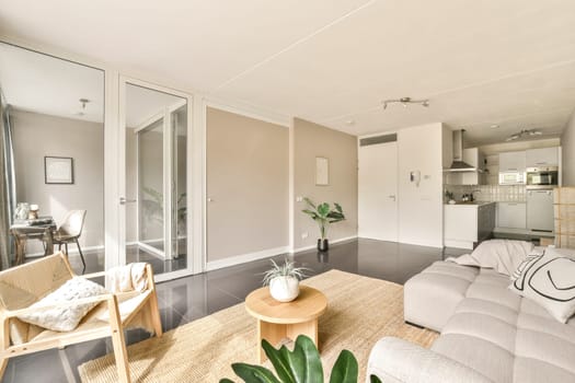 A beautifully designed modern interior featuring a cozy seating area, contemporary furnishings, and an open kitchen space. Elegant and inviting ambiance.