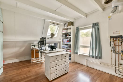 A spacious and well-lit sewing room featuring a workstation, shelves filled with supplies, and natural light streaming through large windows.