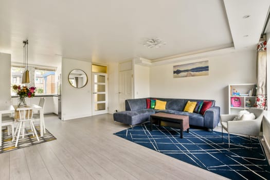 Stylish modern living room featuring a cozy seating area, a decorative rug, and bright natural light enhancing the warm atmosphere.