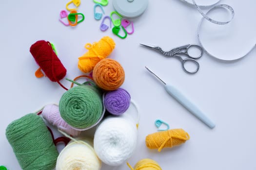 Colorful yarn and crochet tools on white background.