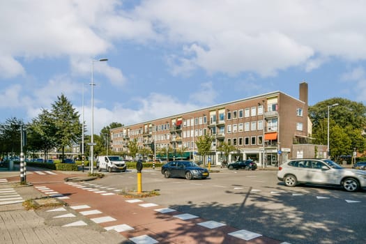 A vibrant urban scene featuring modern architecture, vehicles, and lush greenery, depicting a lively intersection amidst a clear sky.