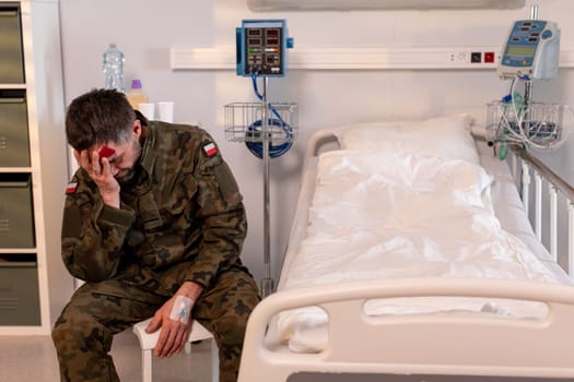 A soldier sits alone in a hospital, visibly distressed, reflecting the emotional toll of their service experience