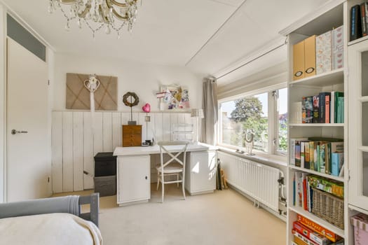 A spacious home office with a clean design featuring a white desk, bookshelves filled with colorful books, and a bright window view, creating a motivating workspace.