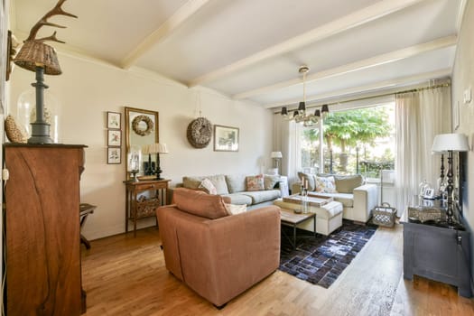 A stylish living room with comfortable seating, wooden accents, and large windows allowing plenty of natural light to brighten the space.