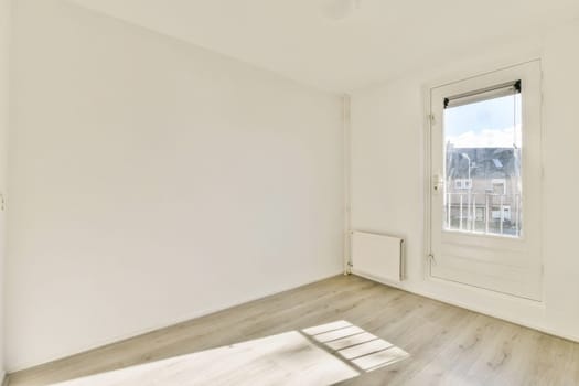 This image features a bright, spacious room with simple decor and large windows allowing natural light to illuminate the space.