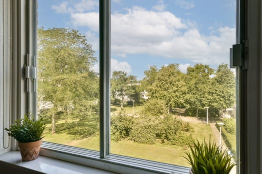 A peaceful outdoor view featuring lush greenery and blue skies as seen through a window, enhancing a serene home atmosphere.