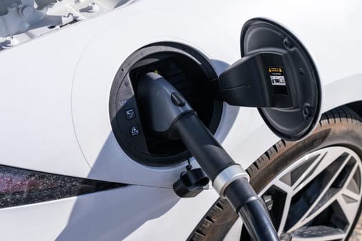 350KW high speed EV charging cable plugged into a white car being charged
