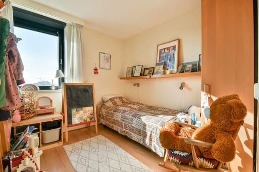 A well-lit children's bedroom featuring a bed, playful decor, and cozy furniture elements. The room is bright and inviting, perfect for relaxation and play.