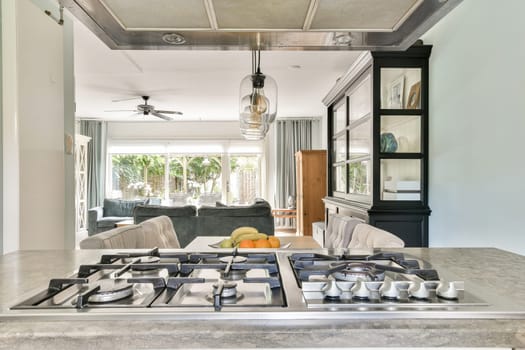 An inviting modern kitchen featuring a sleek gas stove, elegant cabinetry, and a spacious open layout that connects to a bright living area filled with natural light.