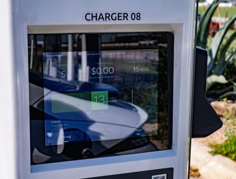 Austin, TX - 11 April 2025: Electrify America EV charger screen reflecting white car using free charging promotion for Hyundai