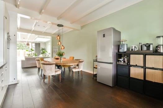 A stylish kitchen featuring a sophisticated dining area, sleek refrigerator, and warm lighting, perfect for entertaining and everyday meals.
