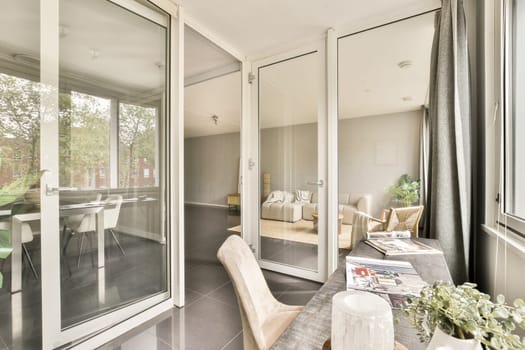 This spacious interior features glass doors, minimalist furniture, and natural light, creating a tranquil living environment blended with modern aesthetics.
